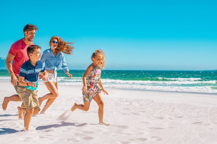 family-running-through-beach